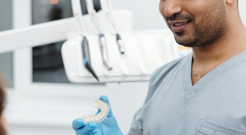 dentist holding teeth aligners