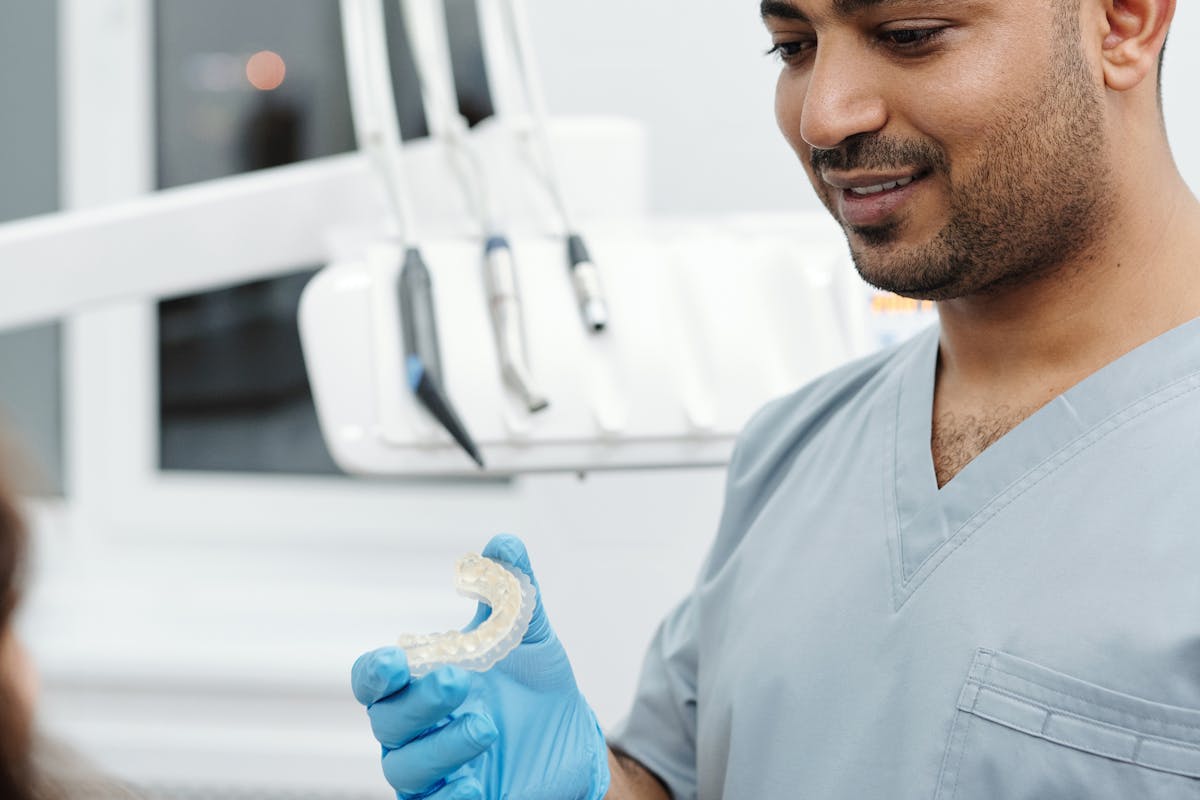 dentist holding teeth aligners